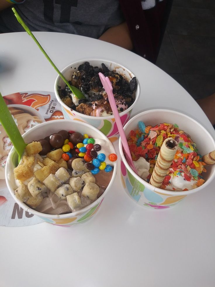 three cups filled with different types of food on top of a white table next to each other