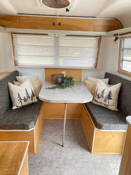 the inside of a camper with two couches and a table