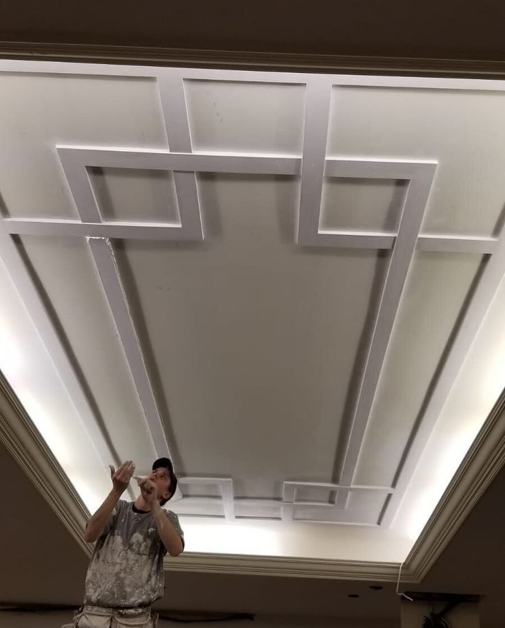 a man standing in front of a white ceiling