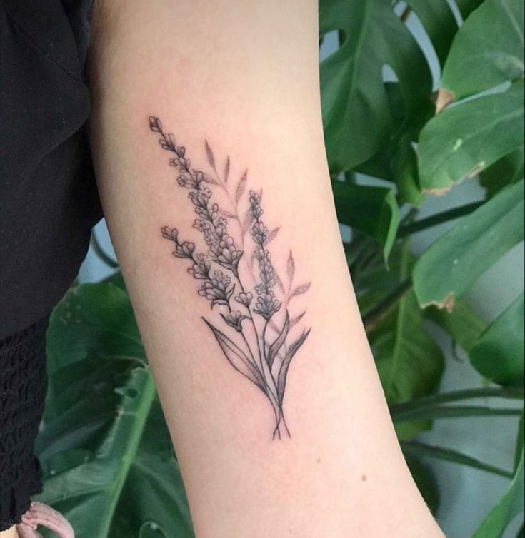 a woman's arm with a flower tattoo on the left side of her arm