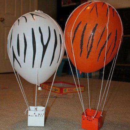 two hot air balloons that look like zebra stripes and oranges are on the floor