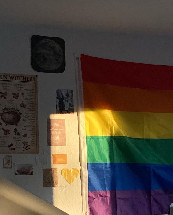 a rainbow colored flag hanging from the side of a wall