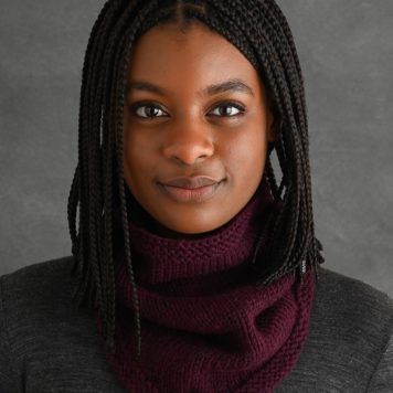 a woman with dreadlocks wearing a scarf