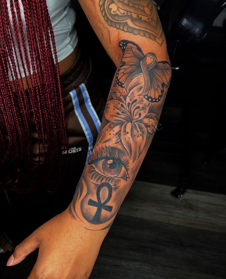 a woman's arm with an all seeing eye tattoo on her left arm and the word