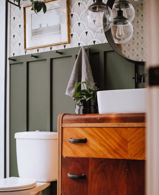 a bathroom with a sink, mirror and toilet paper dispenser on the wall