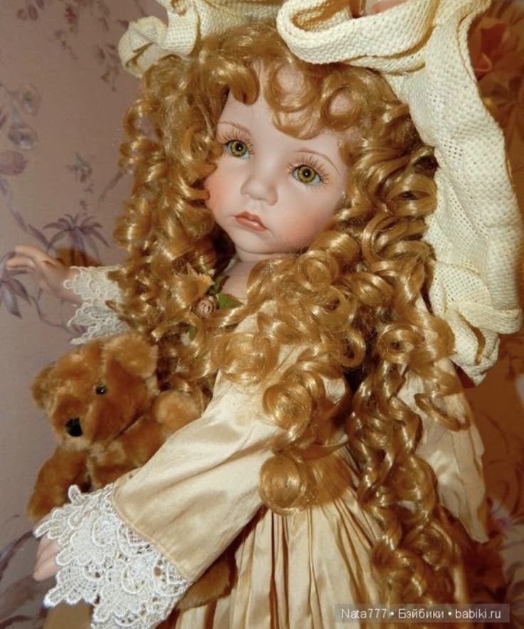 a close up of a doll with curly hair holding a teddy bear in her arms