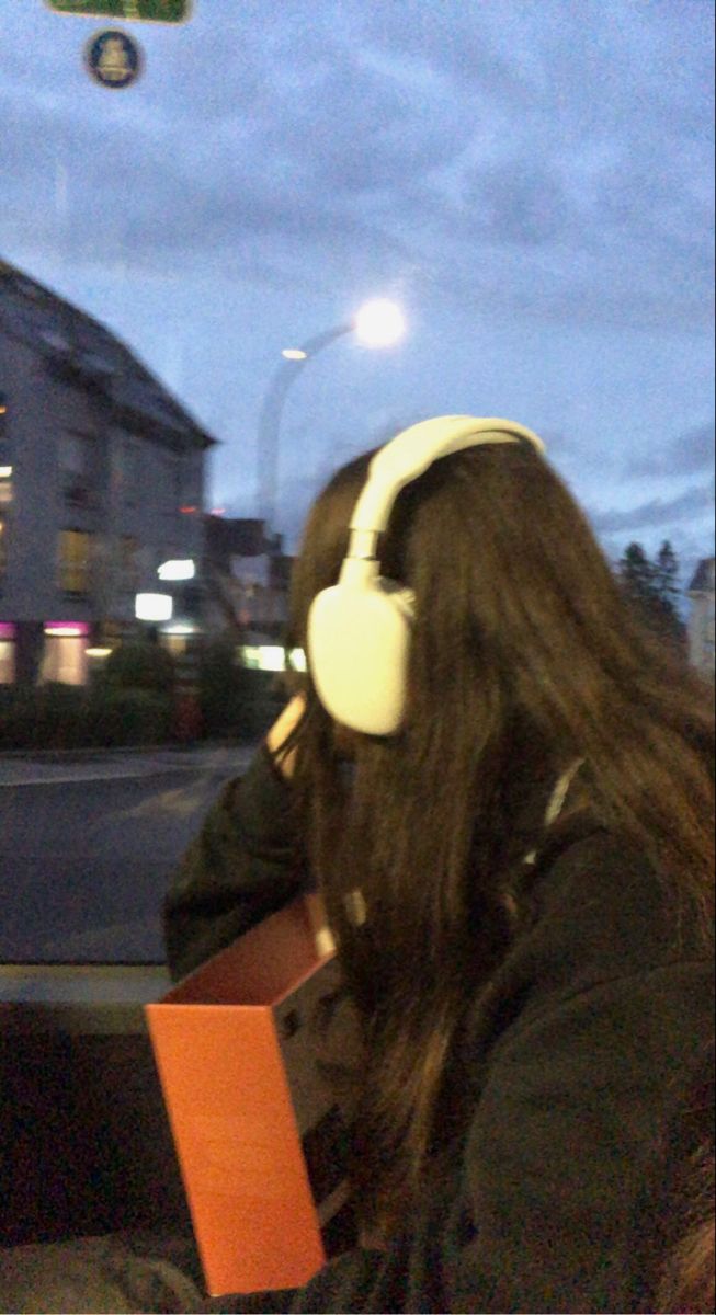 a woman with headphones sitting on a bus