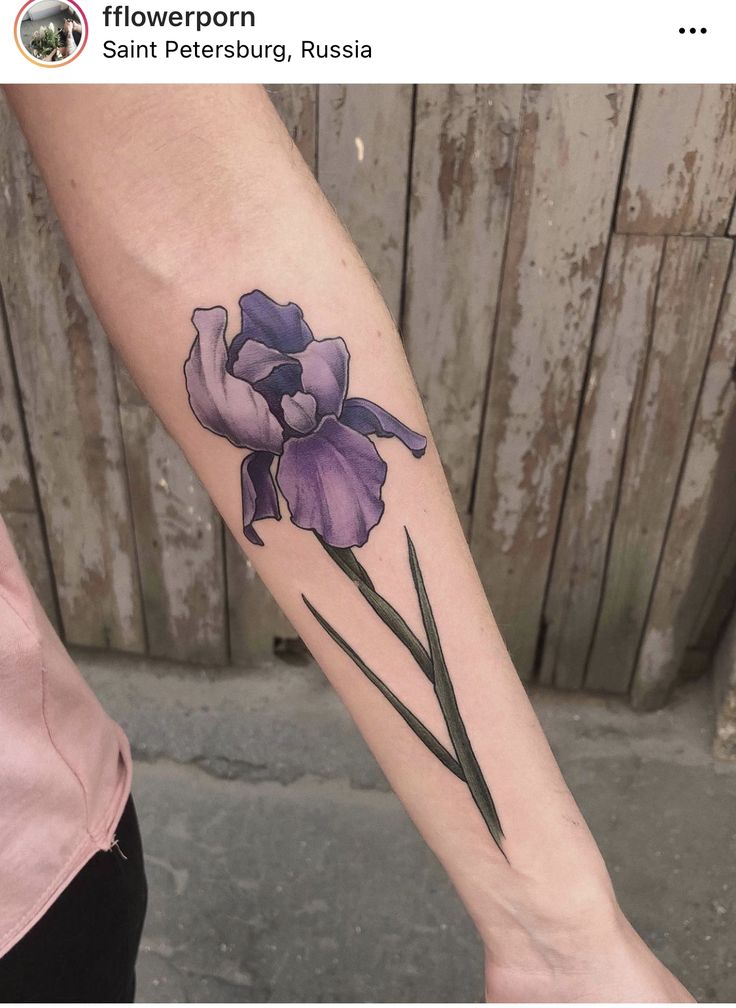 a woman's arm with a purple flower tattoo on it