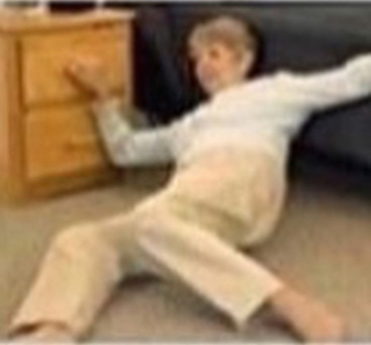 a blurry photo of a young man laying on the floor next to a dresser