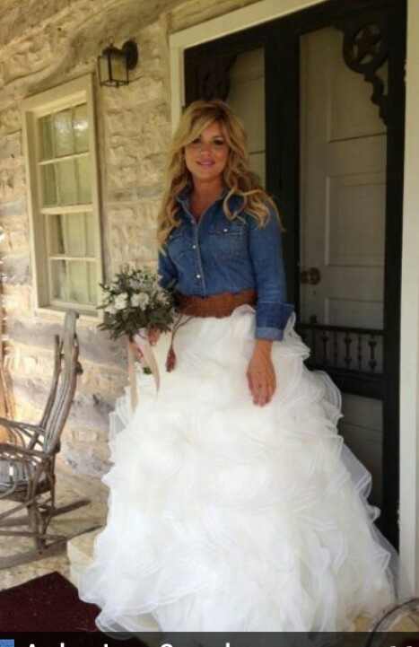 a woman in a white wedding dress standing on the front porch with her hand in her pockets