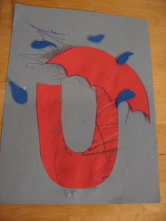 the letter u is made out of paper with blue and red paint on it's surface