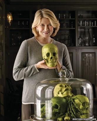 a woman holding a green skull under a glass dome