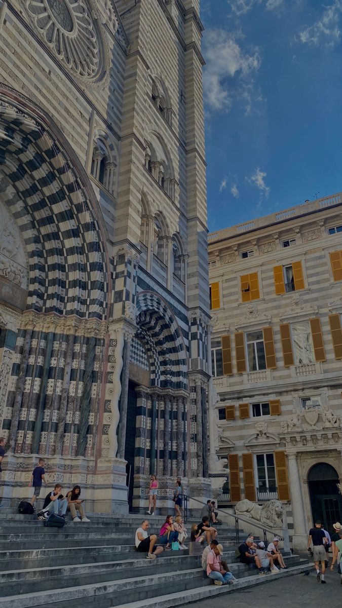 people are sitting on the steps in front of an ornate building