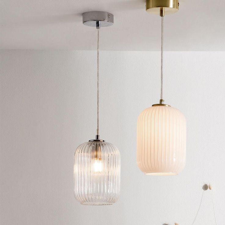 two glass pendant lights hanging from the ceiling