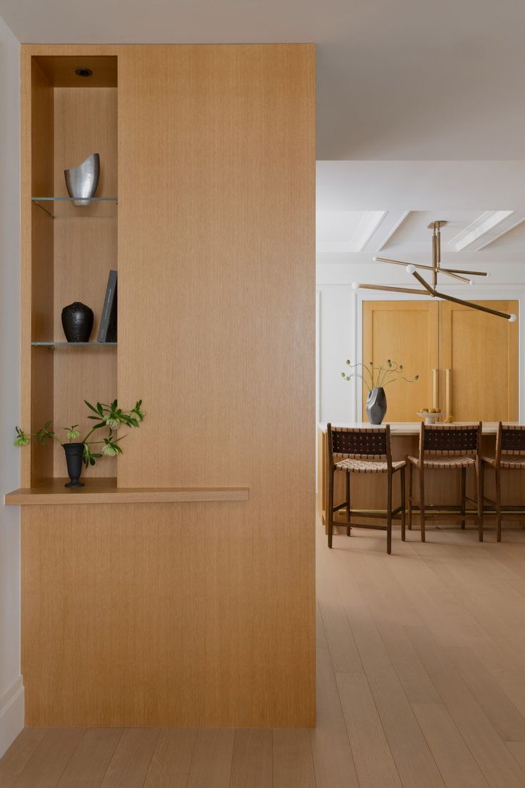 an empty dining room with wooden shelves and chairs