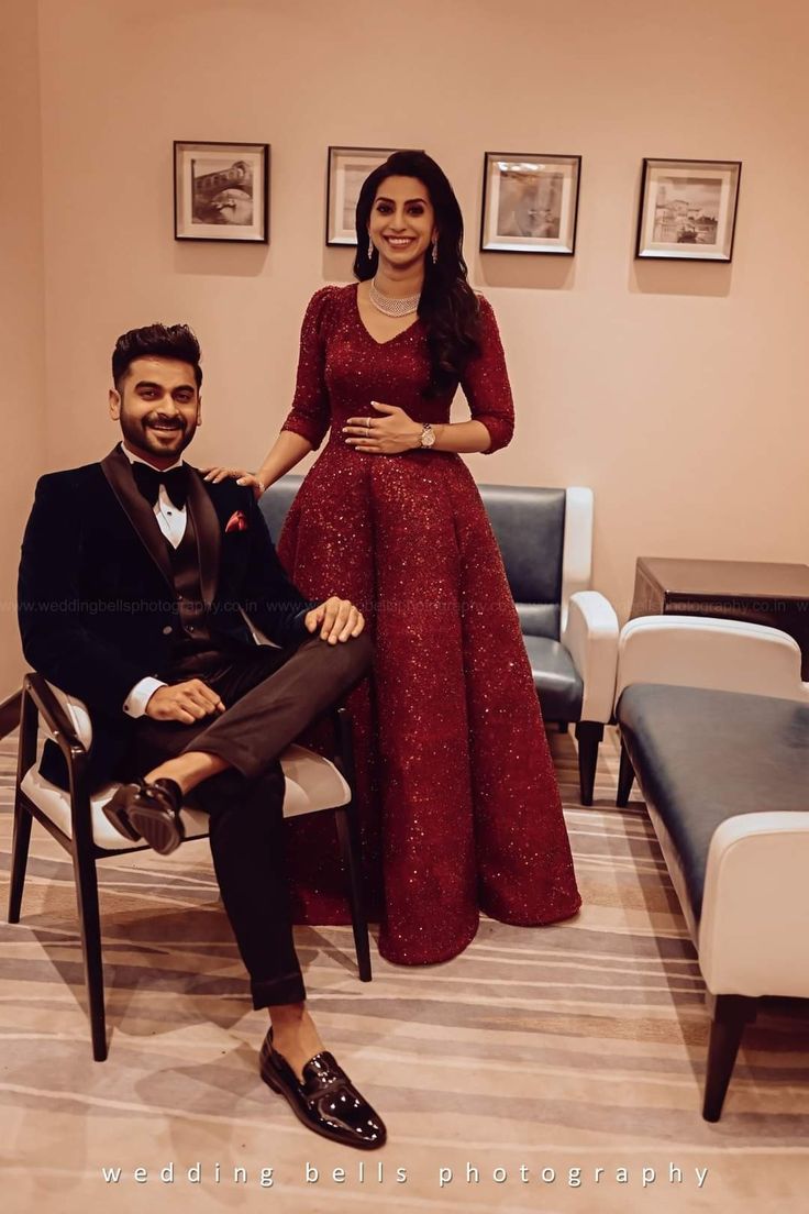 a man and woman in formal wear posing for the camera