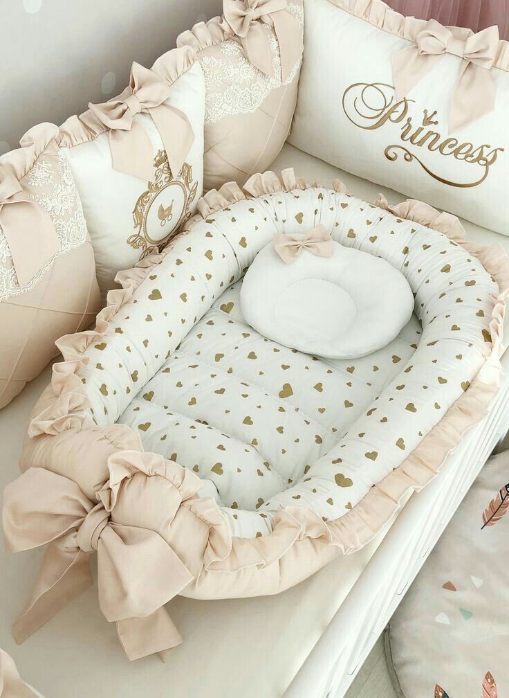 a baby crib that has some pillows on top of it and a pillow in the shape of a heart