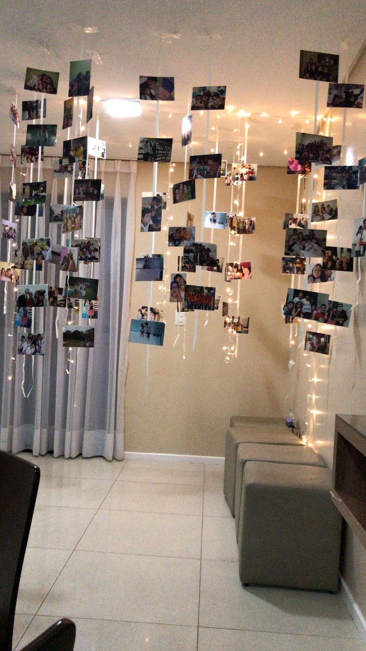 a living room filled with furniture and pictures hanging from the ceiling