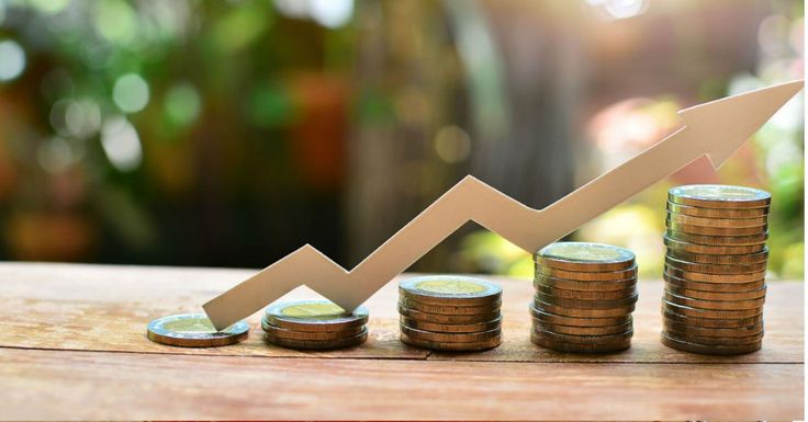 stacks of coins stacked on top of each other with an upward graph going up in the background