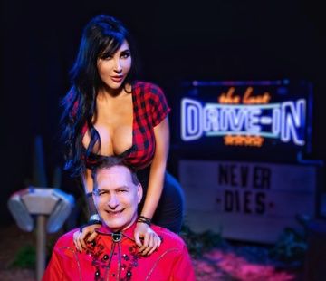 a man sitting on top of a woman's head in front of a neon sign