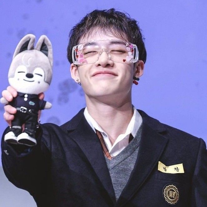 a man holding up a stuffed animal in his hand