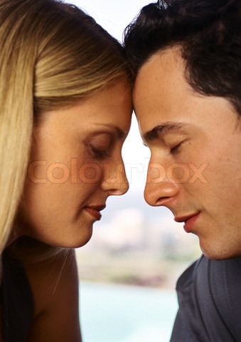 a young man and woman are looking at each other's foreheads while they look into each others eyes