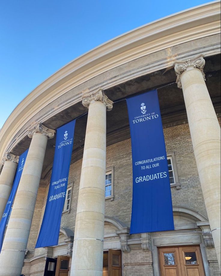 two large pillars with blue banners in front of a building