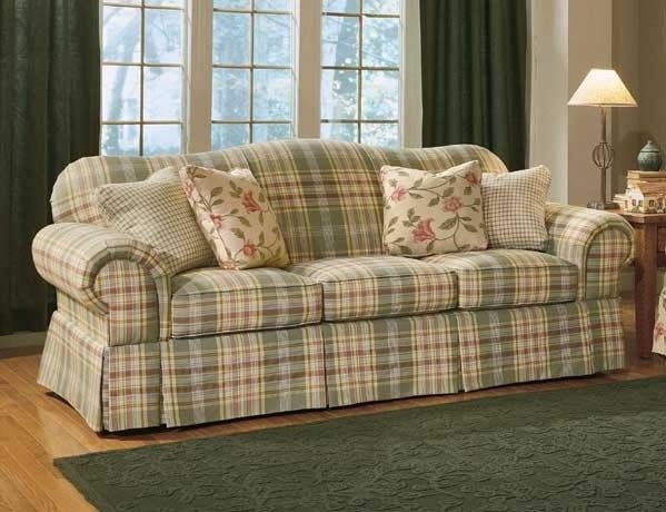 a living room filled with furniture next to a green rug on top of a hard wood floor