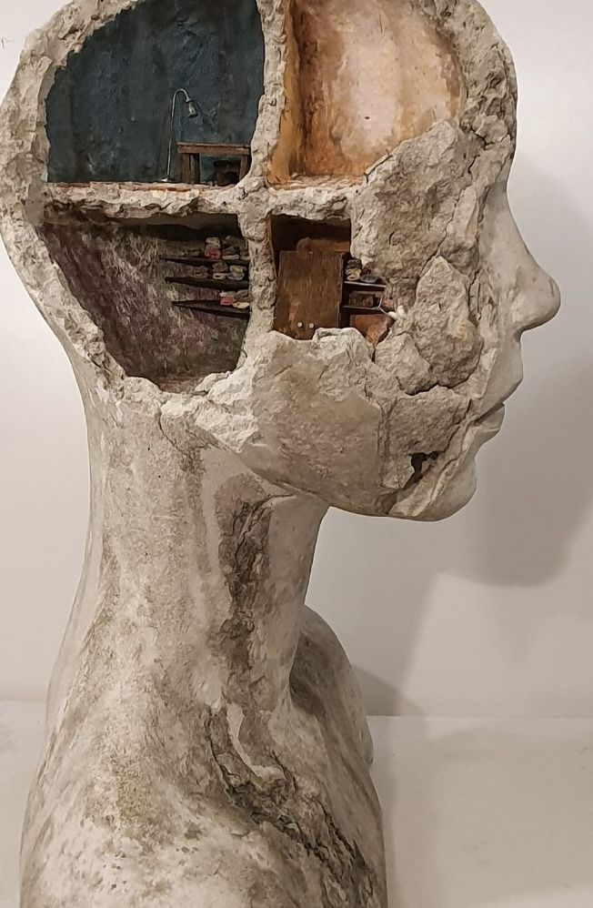 a sculpture of a person's head with a hole in the side to it