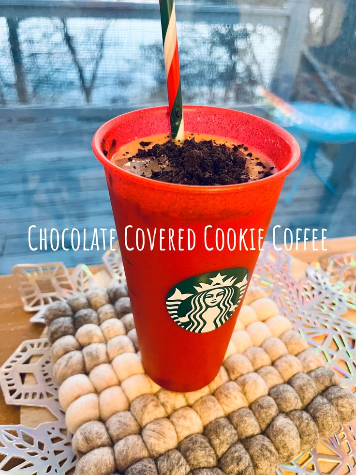 a red cup filled with chocolate covered cookies and a candy cane sticking out of it