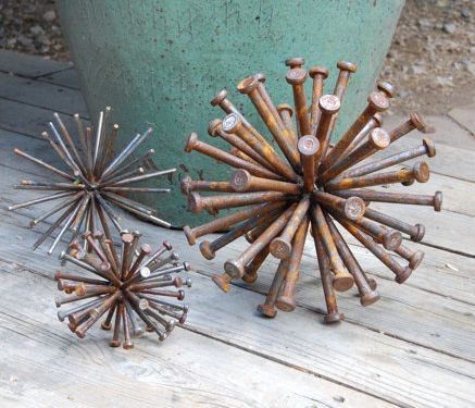 three rusty spiky metal objects sitting next to each other on a wooden floor