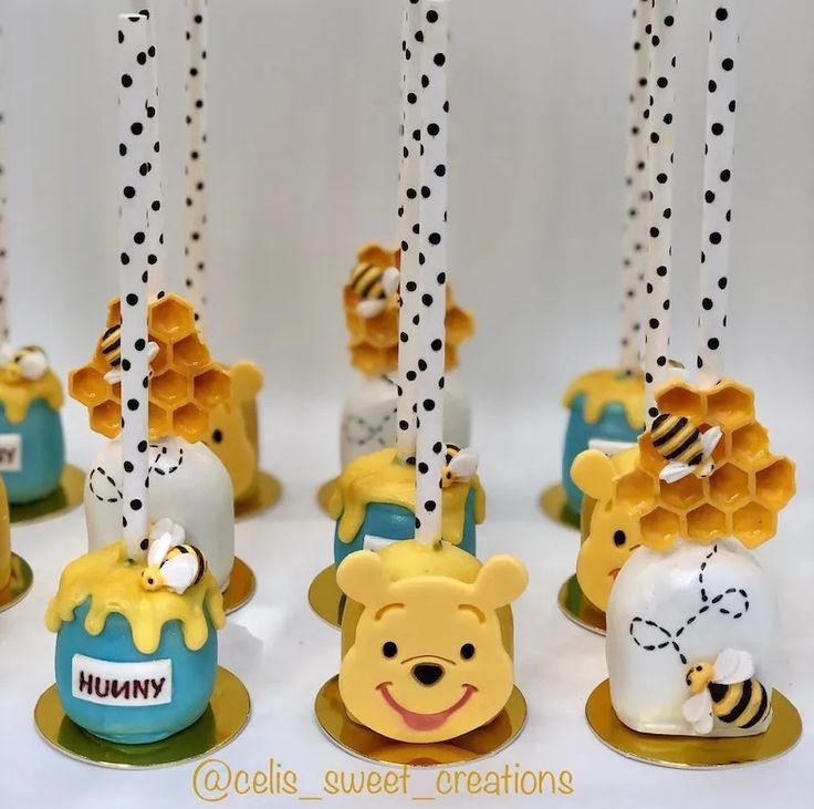 winnie the pooh cake pops are decorated with honeycombs and polka dot candles