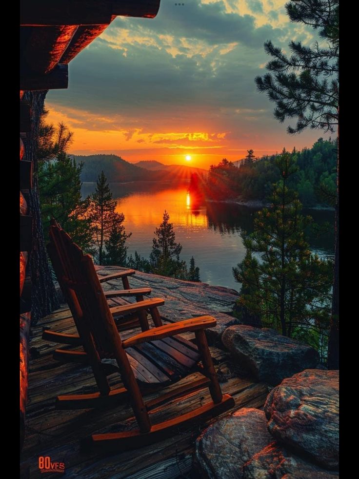 two wooden chairs sitting on top of a wooden deck next to a body of water