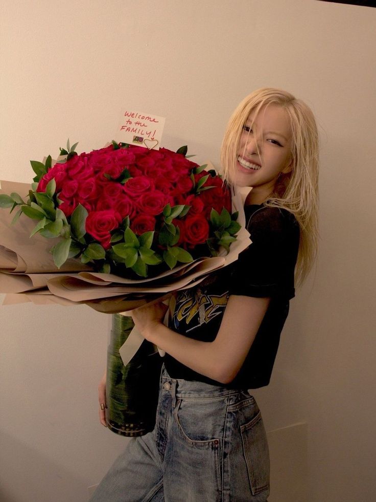 a woman holding a bouquet of red roses