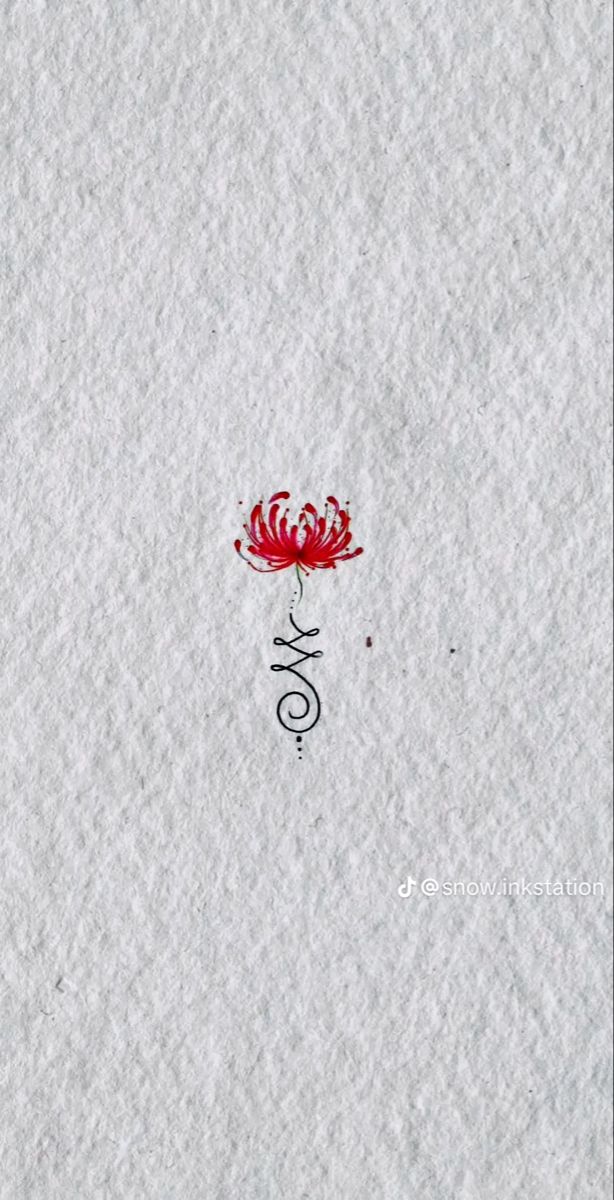 a red flower sitting on top of a white paper with chinese writing in the middle