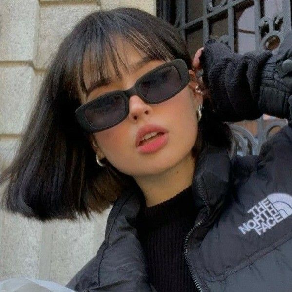 a woman wearing sunglasses and a black jacket