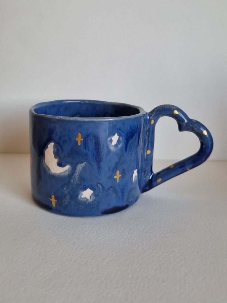 a blue mug with stars and moon designs on it