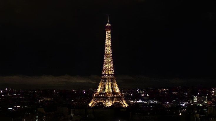 the eiffel tower is lit up at night