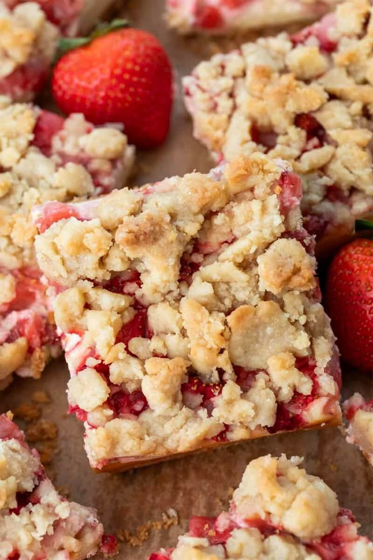 strawberry crumb bars cut into squares and topped with fresh strawberries