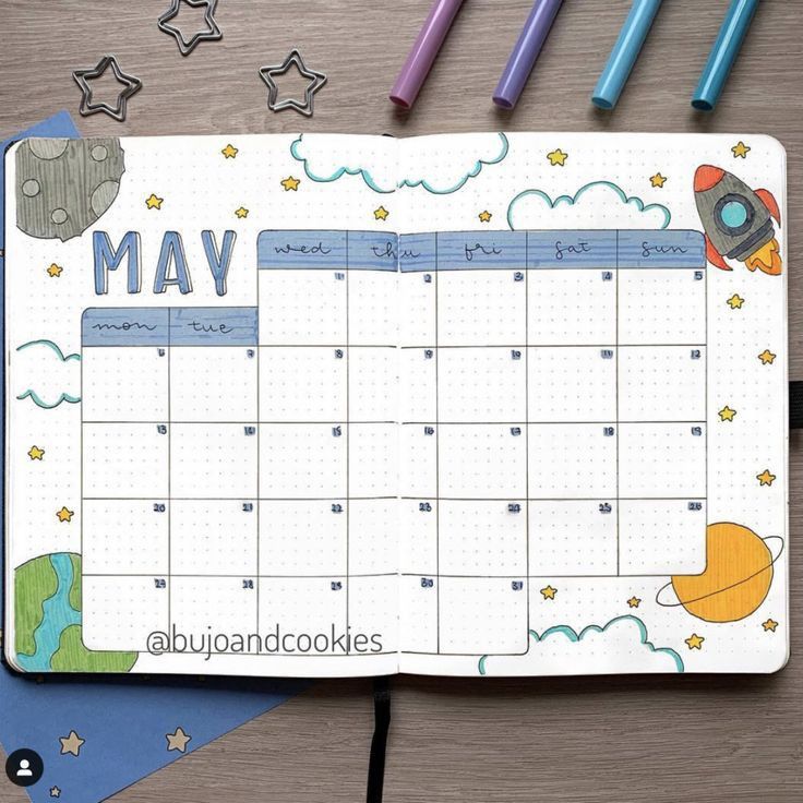 a calendar on a desk with markers and pencils