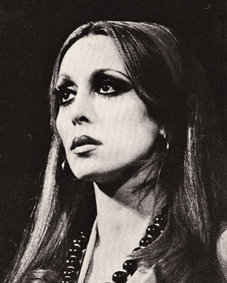 black and white photograph of woman with long hair wearing pearls on her necklace, looking off to the side