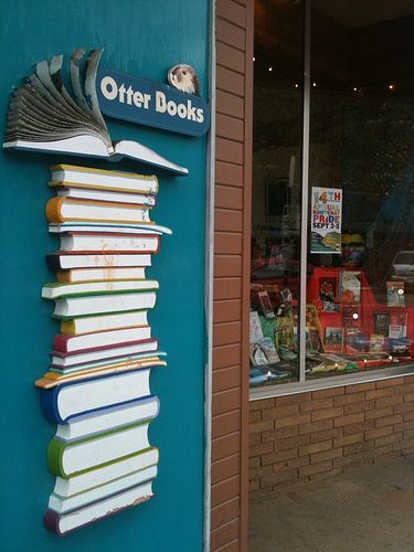 a stack of books sitting on the side of a building next to a store front