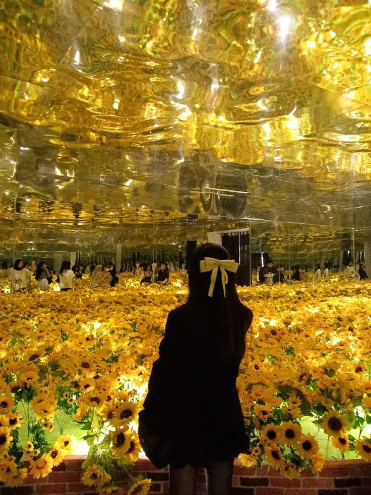 a person standing in front of a field full of sunflowers