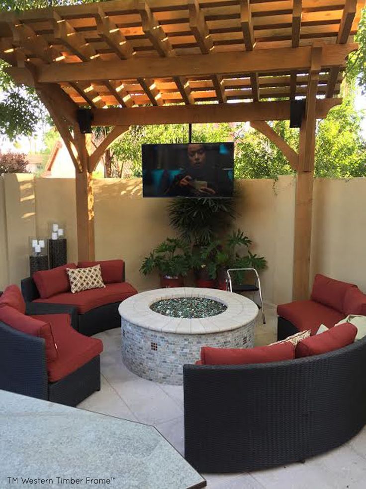 an outdoor living area with couches, chairs and a fire pit in the middle