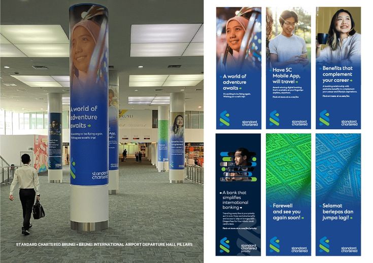 a woman walking through an airport lobby next to large blue and white pillars with advertisements on them