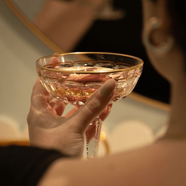 a woman holding a wine glass in front of her face