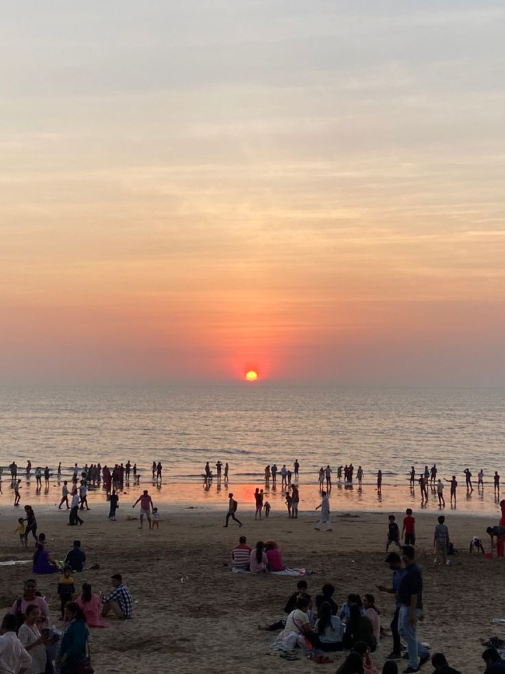 many people are on the beach at sunset or sunrise, and there is no image here to provide a caption for