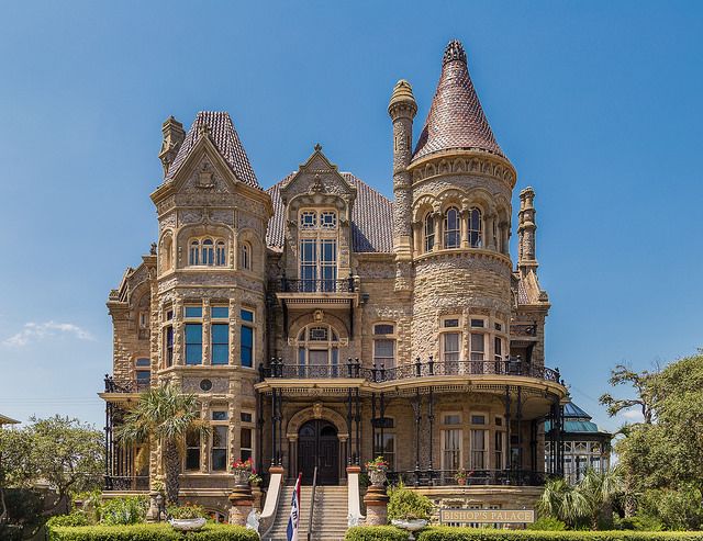 an old victorian style house with turrets on the roof and stairs leading up to it