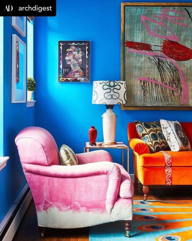 a living room with blue walls and pink furniture in it's centerpieces