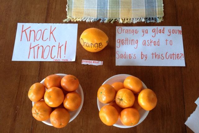 oranges are sitting in bowls on a table with signs and other items around them